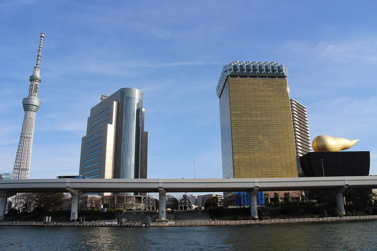 Tokyo Skytree rising above the Sumida River next to the Asahi Beer headquarters building