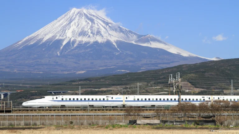 在靜岡縣行駛的 Tokaido Shinkansen N700 系新幹線，背後是積雪的富士山