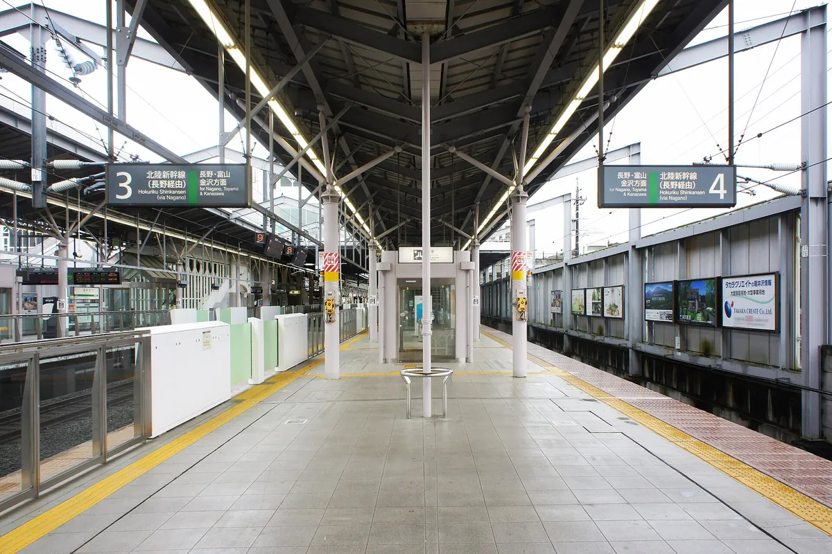 Covered shinkansen platform with signage at Karuizawa Station on the Hokuriku Shinkansen line