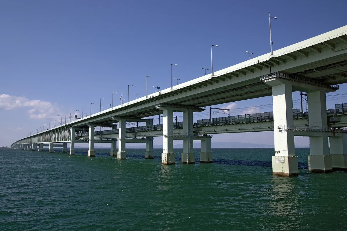 Sky Gate Bridge R, a two-level bridge with a train track below and a road above, crossing the water on tall pillars