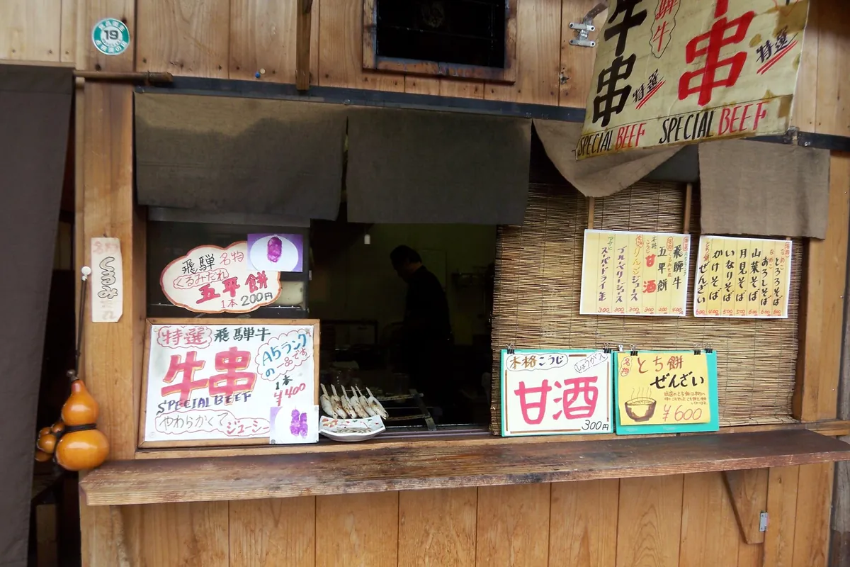 A street food stall in Gifu selling Hida beef skewers with a Special Beef sign