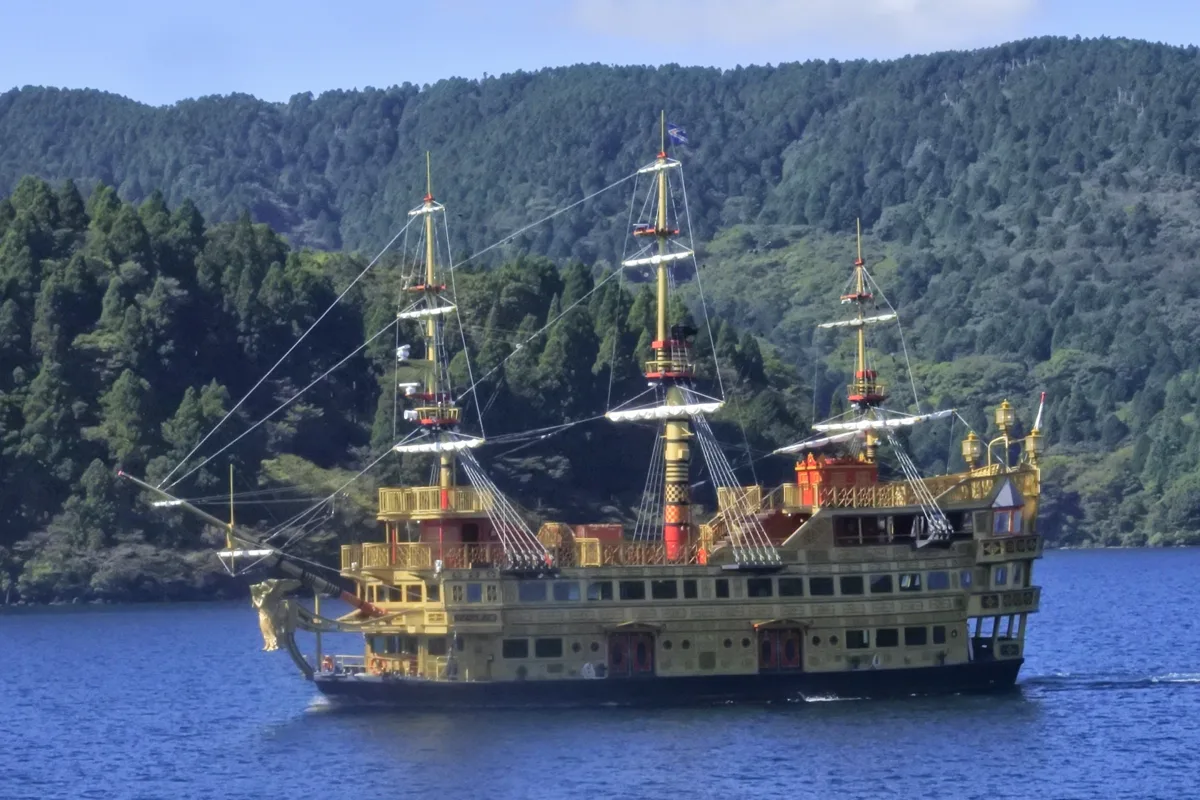 The pirate-ship style sightseeing boat Queen Ashinoko on Lake Ashi in Hakone, with forested hills behind, in 2022