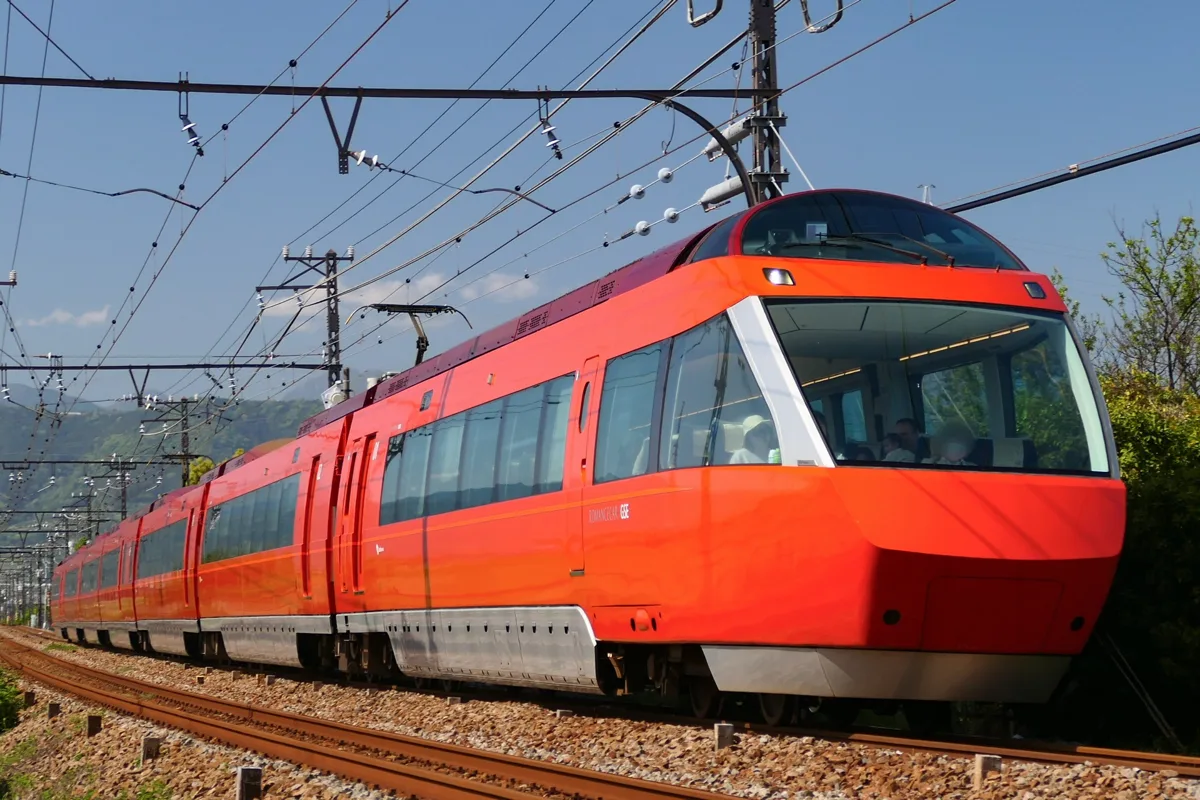 An Odakyu 70000 series GSE Romancecar in red-orange, running as a limited express to Hakone-Yumoto, in 2024