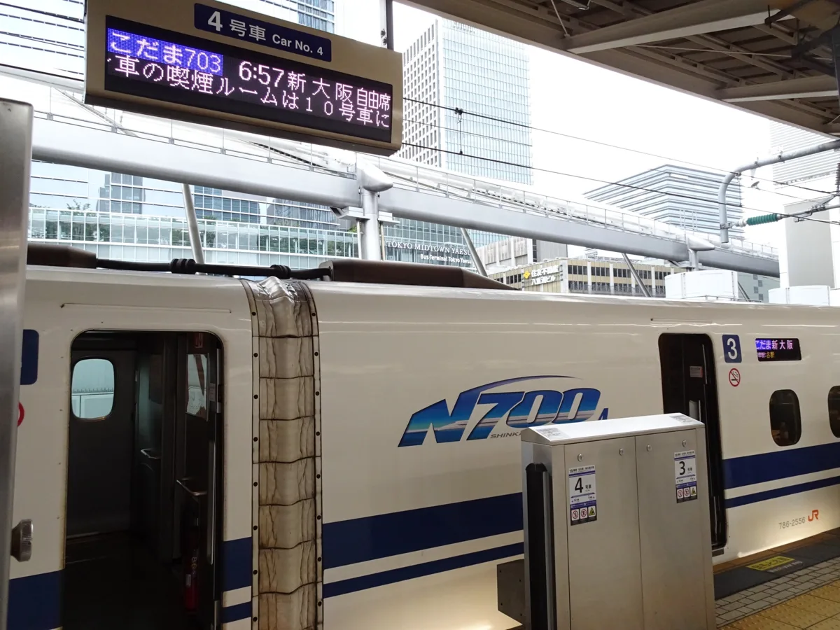 A sign above car 4 at Tokyo Station showing the 6:57 Kodama 703 to Shin-Osaka with non-reserved seats, next to an N700A.
