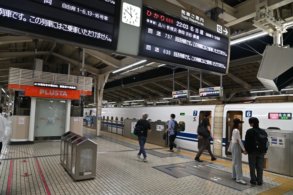 A departure board on platform 15 at Tokyo Station showing the 22:03 Hikari 669 to Nagoya, with an N700S train and.