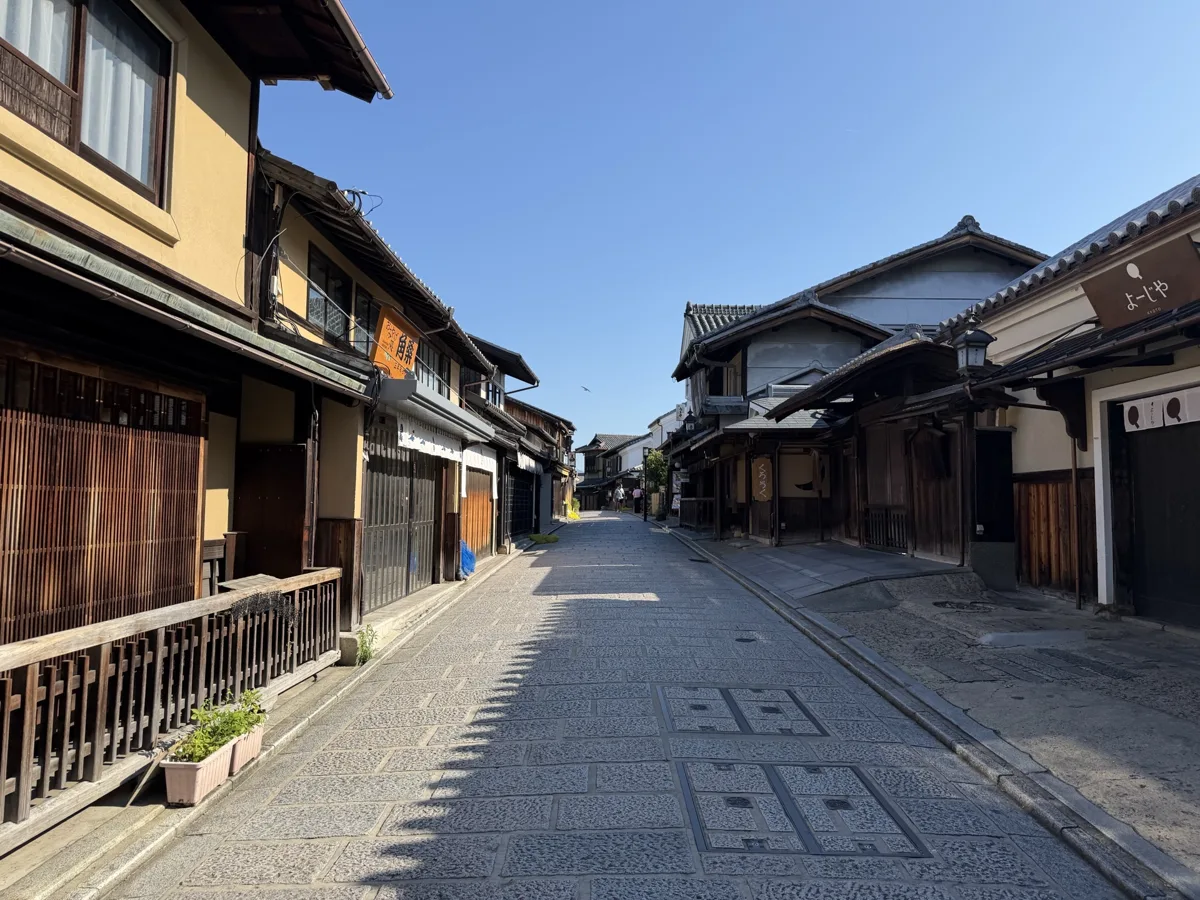 The stone-paved Sannenzaka slope on the approach to Kiyomizu-dera in Kyoto, lined with traditional wooden shops, with almost.