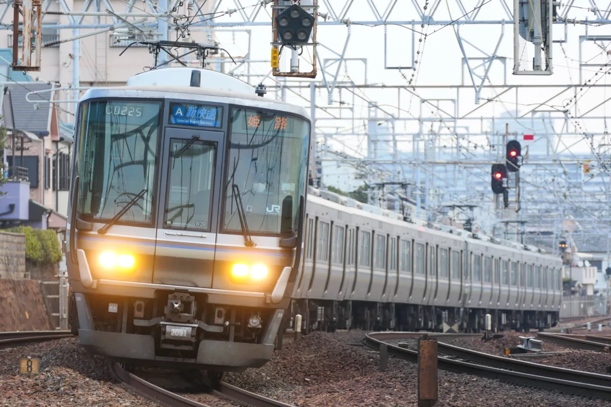 A JR West 223 series train with a Special Rapid display on its front, coming around a curve, in 2021