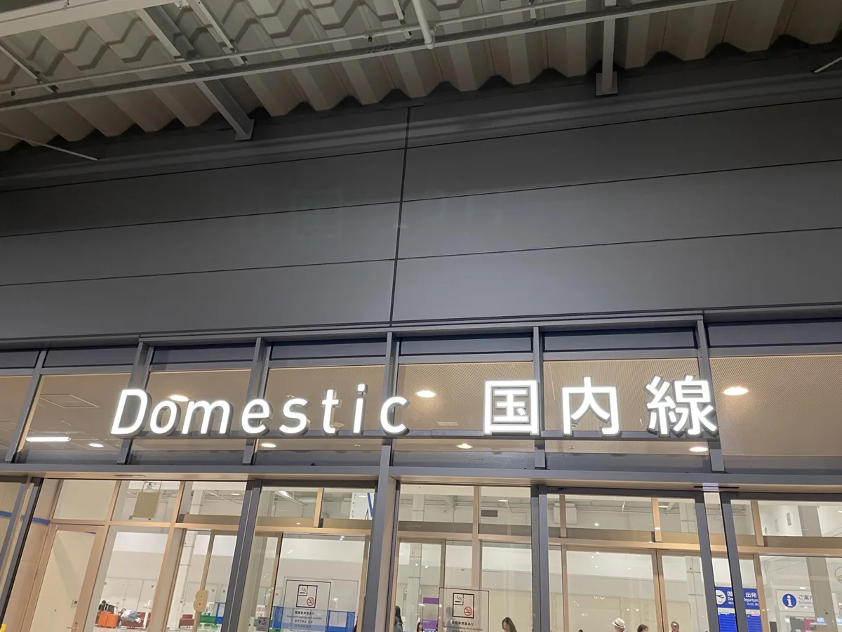 The entrance of Kansai Airport Terminal 2 at night, with the sign Domestic in English and Japanese, in 2026