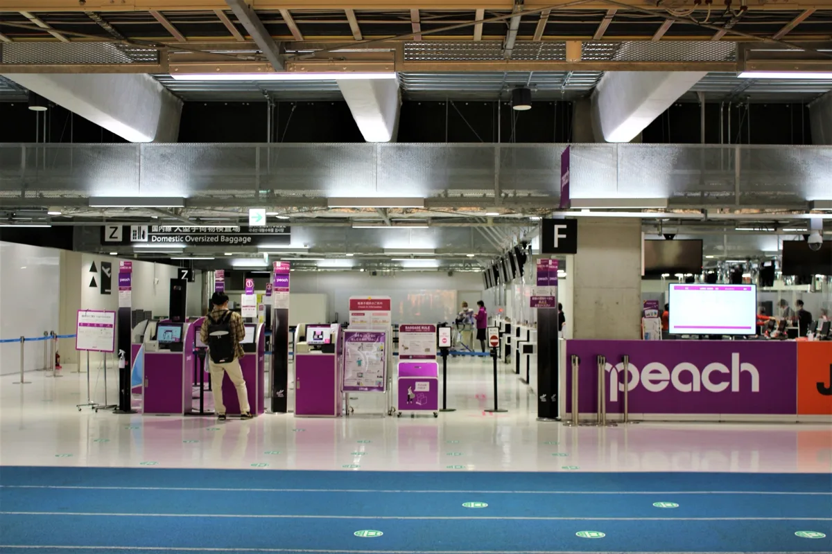 Peach check-in counters and kiosks at Narita Airport Terminal 3, in 2020