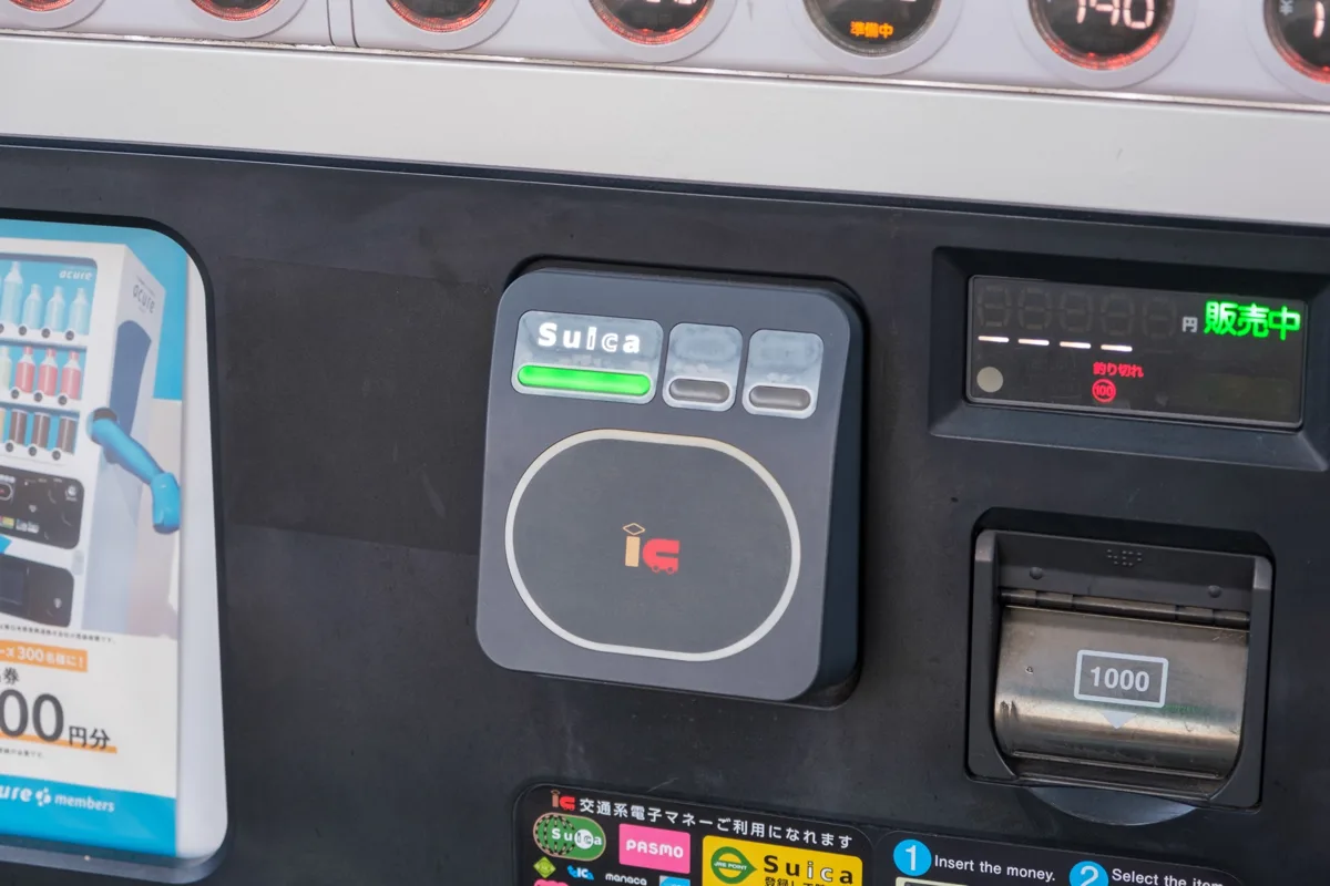 A Suica IC card reader on a drink vending machine, next to the coin and note slots, in 2020
