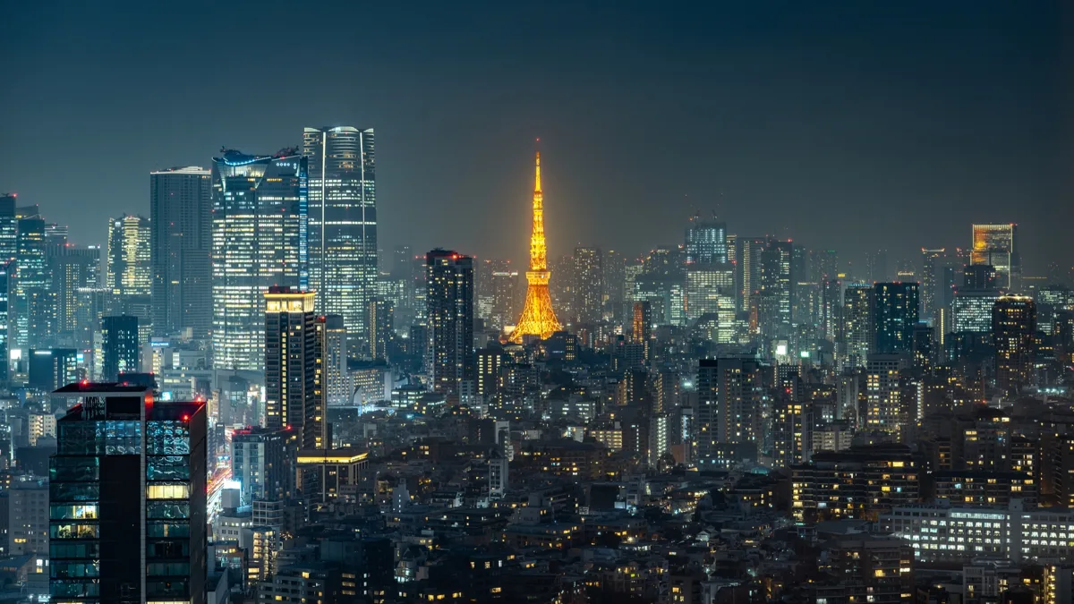 Tokyo Tower lit up in orange among the high-rise buildings of Minato City at night, in 2025