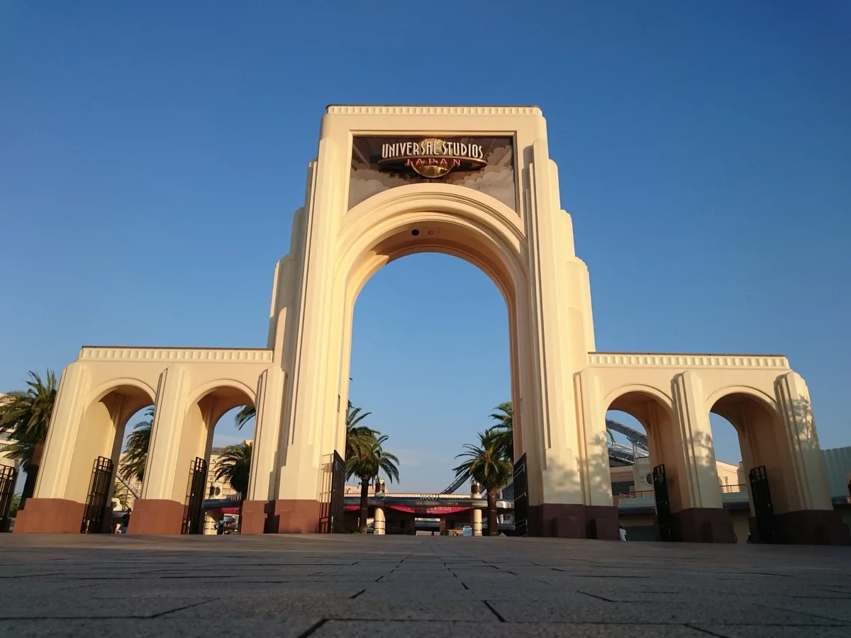 The arched entrance gate of Universal Studios Japan in Osaka under a blue sky, in 2019