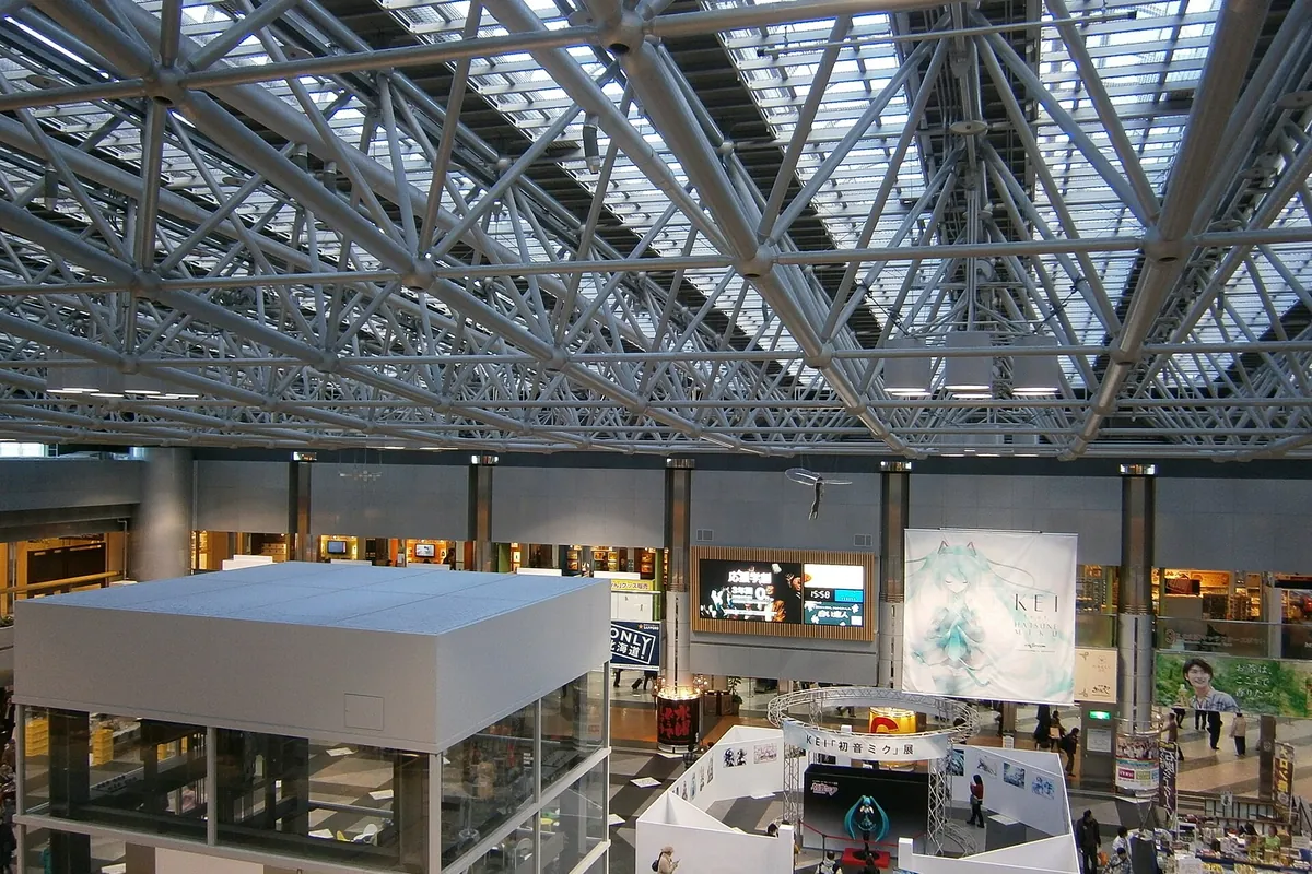 Spacious atrium with a steel truss skylight roof and shops inside the New Chitose Airport terminal building
