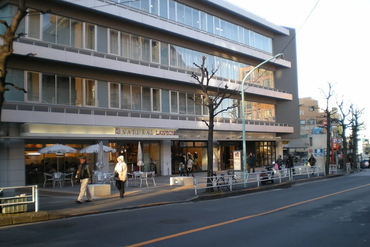 Natural Lawson store front in a building along a street in Tokyo, Japan, with pedestrians walking past