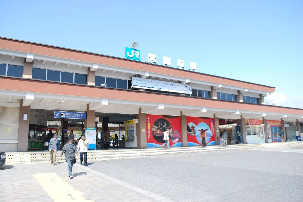 The JR Miyajimaguchi Station building with its signage and murals on the facade