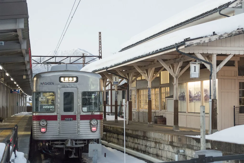 Nagano Electric Railway train at a snow-covered station platform in Yudanaka