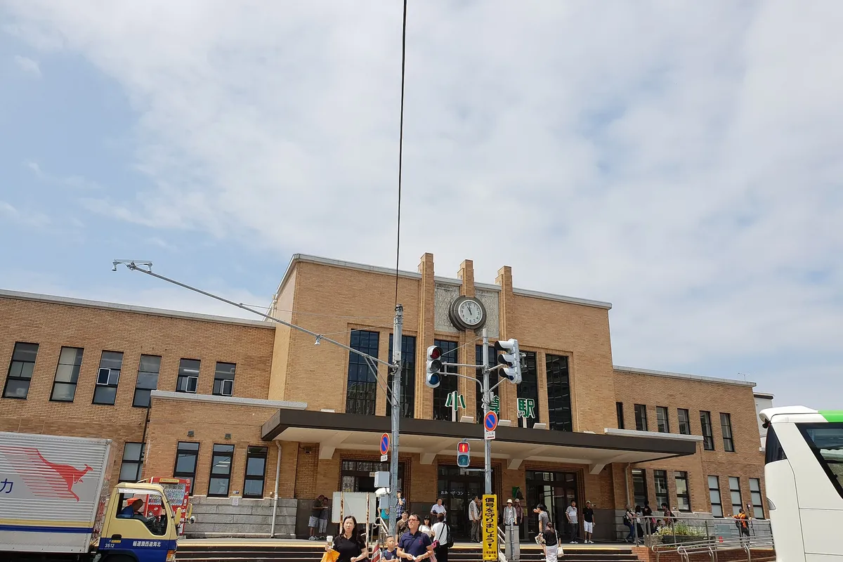 Otaru Station's brick building with a clock tower, seen from the street in Hokkaido