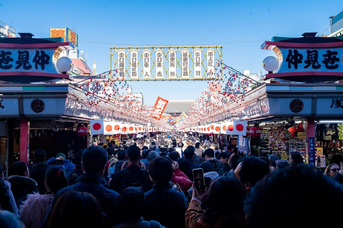 浅草寺の大きな提灯の門に向かって仲見世通りを歩く大勢の人々