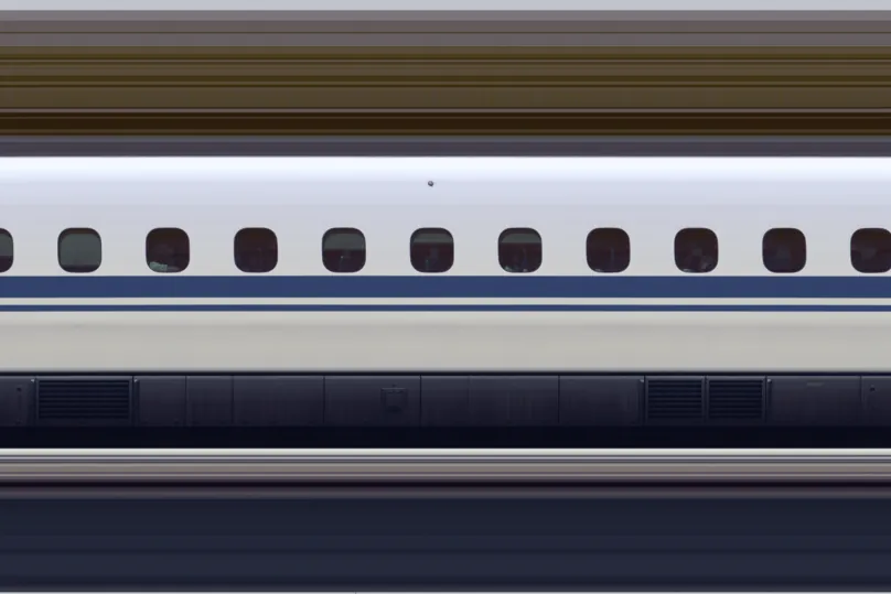 Close-up side view of a white Shinkansen car with a row of windows and a blue stripe along the body