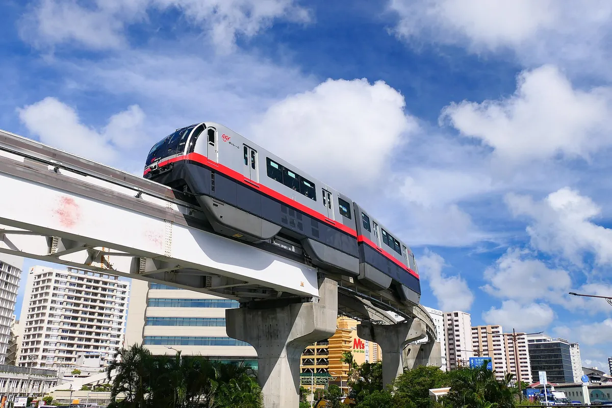 那覇市内の建物の上を走る、沖縄都市モノレール ゆいレールの列車