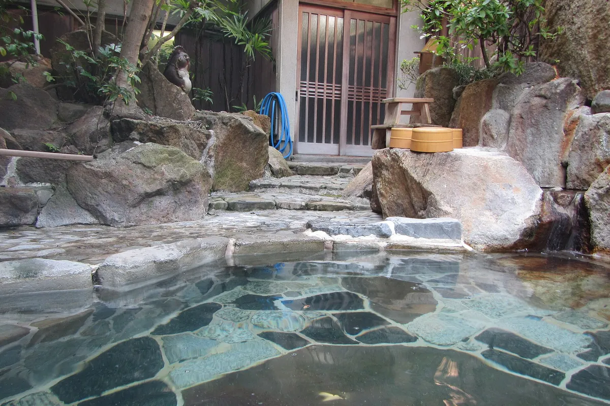 旅館にある、石に囲まれた誰もいない露天風呂
