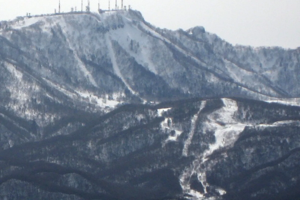 눈 덮인 테이네산. 비탈에 스키 코스가 보이고 정상에는 안테나가 서 있다