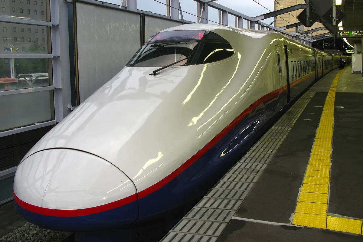 A Hokuriku Shinkansen train waiting at a platform at Nagano Station in Japan