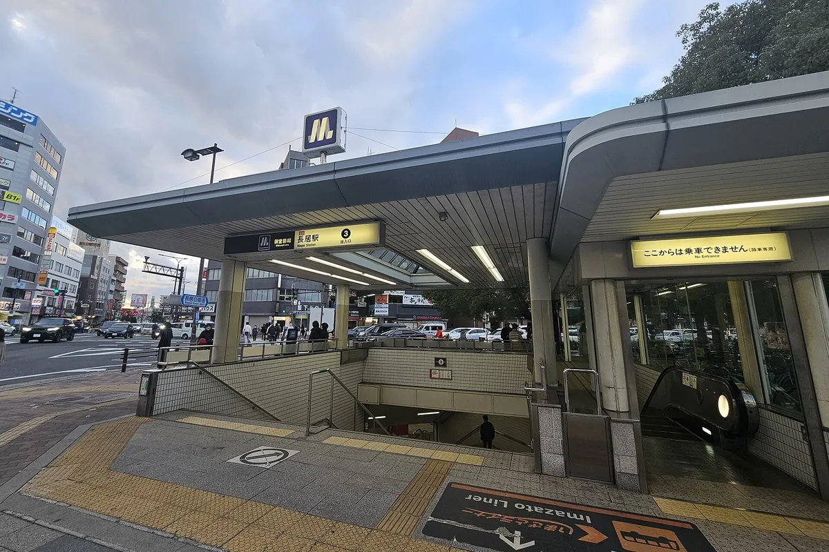 Osaka Metro Nagai Station Exit 3 with escalator, stairs, and signage, next to a street with cars and buildings