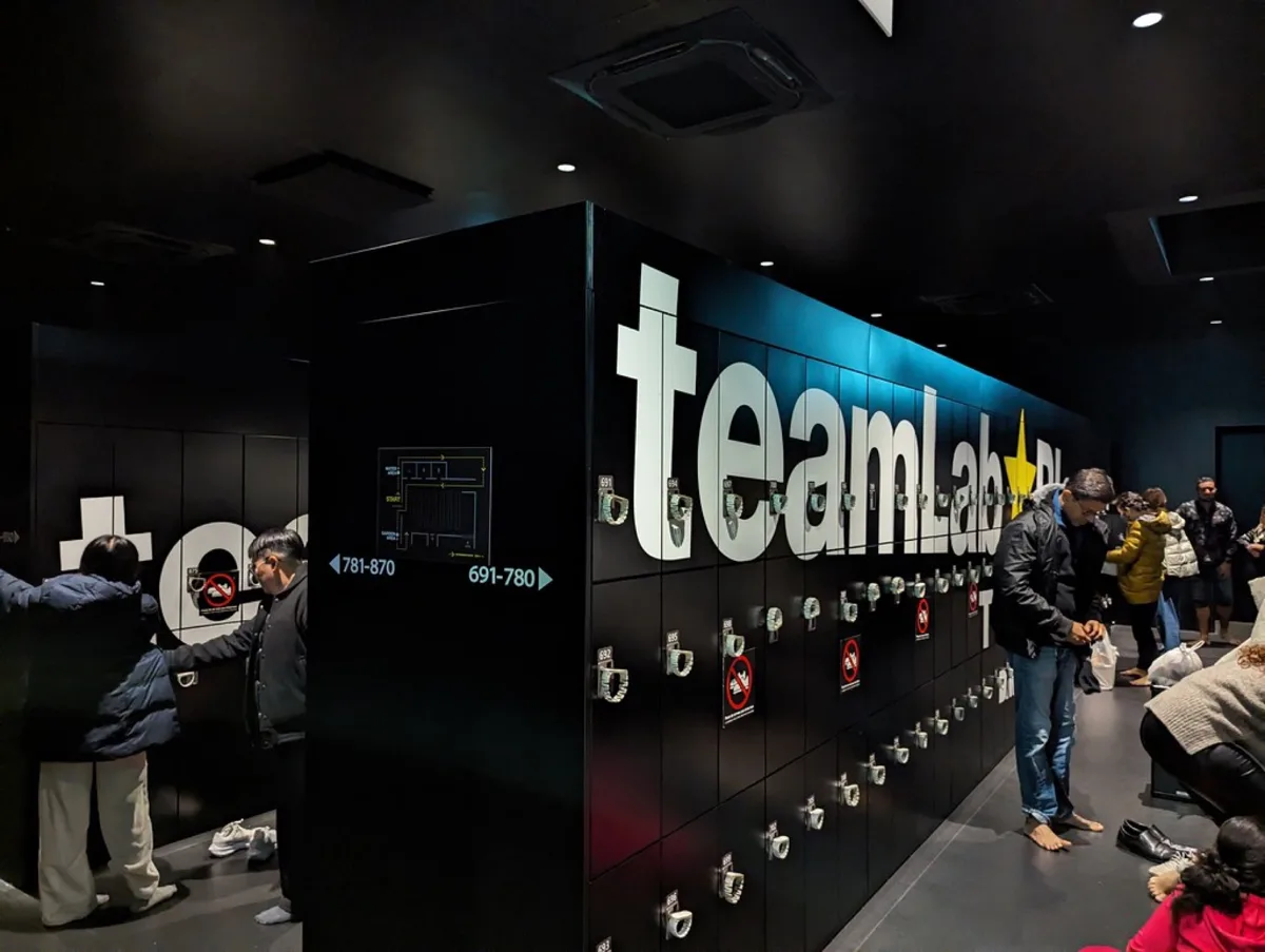 Locker area with large teamLab letters and visitors storing bags