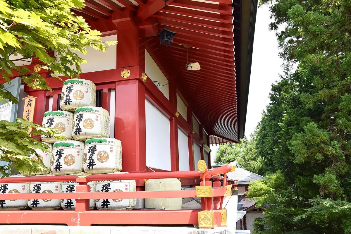 東京・武蔵御嶽神社の赤い軒下に積まれた酒樽