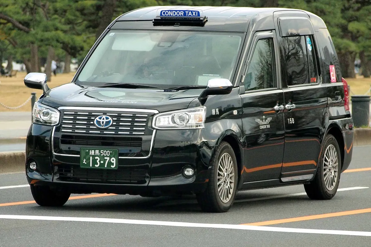 東京・丸の内の街中を走る、Condor Taxiの社名表示を付けた黒いトヨタJPN TAXI