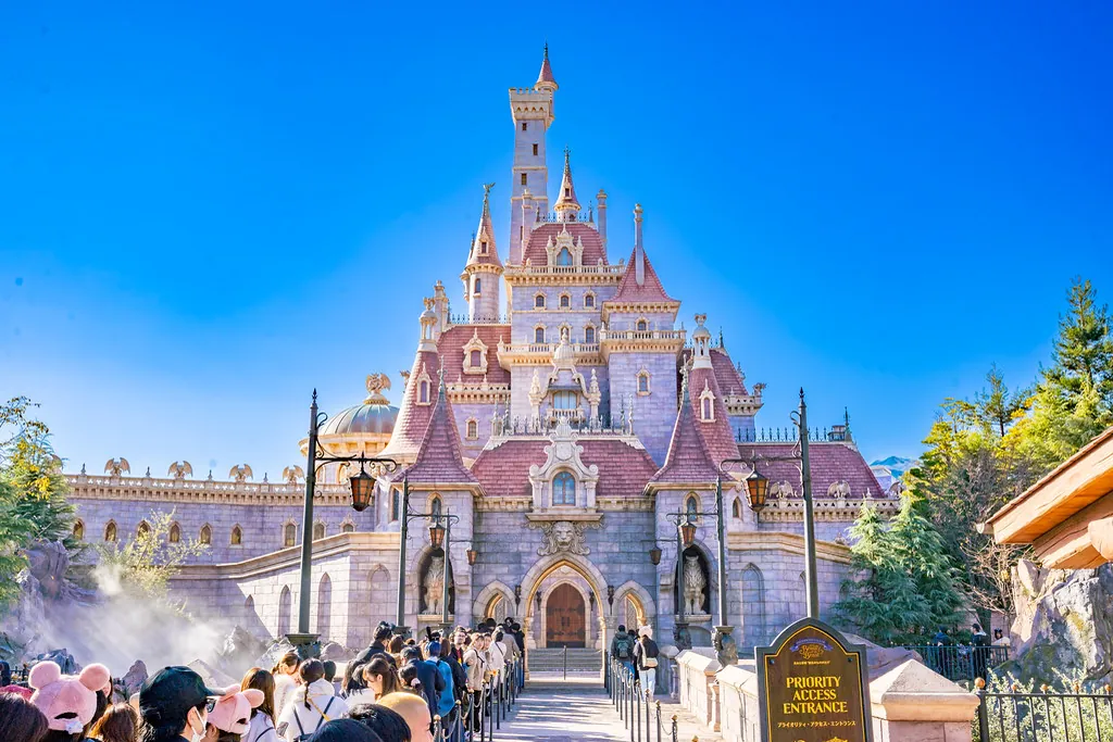Beauty and the Beast castle attraction at Tokyo Disneyland with visitors queuing near the Priority Access Entrance sign