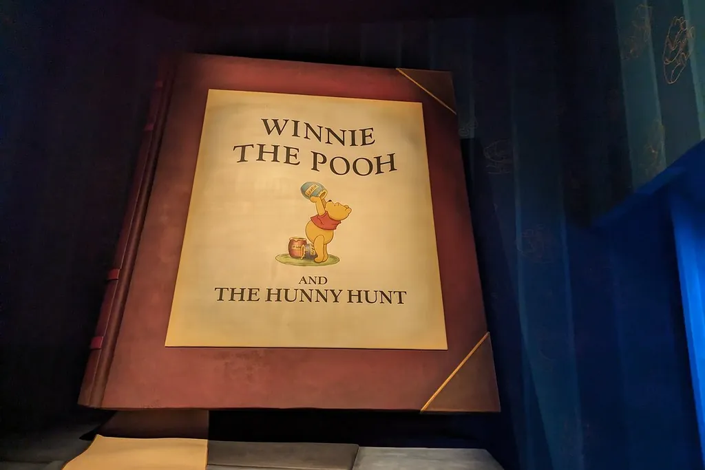 东京迪士尼乐园一本写着Winnie the Pooh and the Hunny Hunt的巨型故事书，维尼正伸手去够蜂蜜