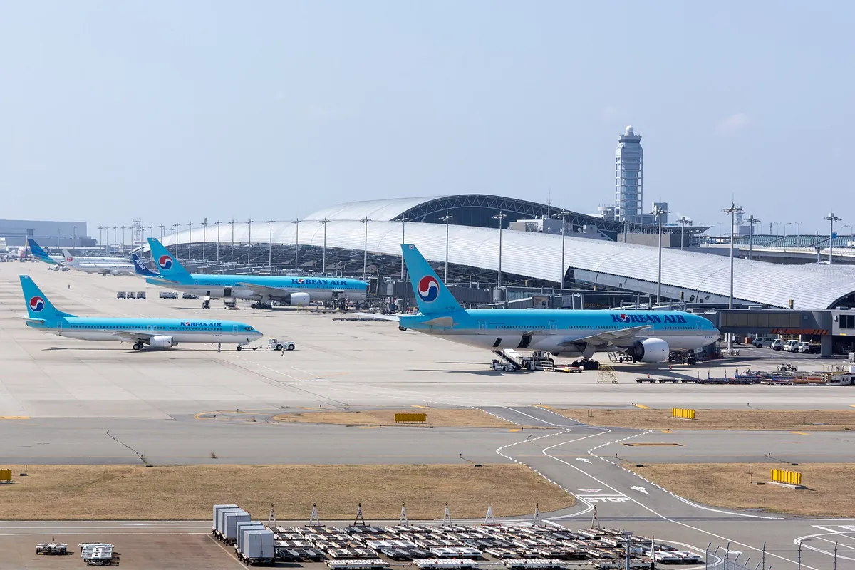 Korean Air planes on the apron in front of the long white roof of Kansai International Airport Terminal 1