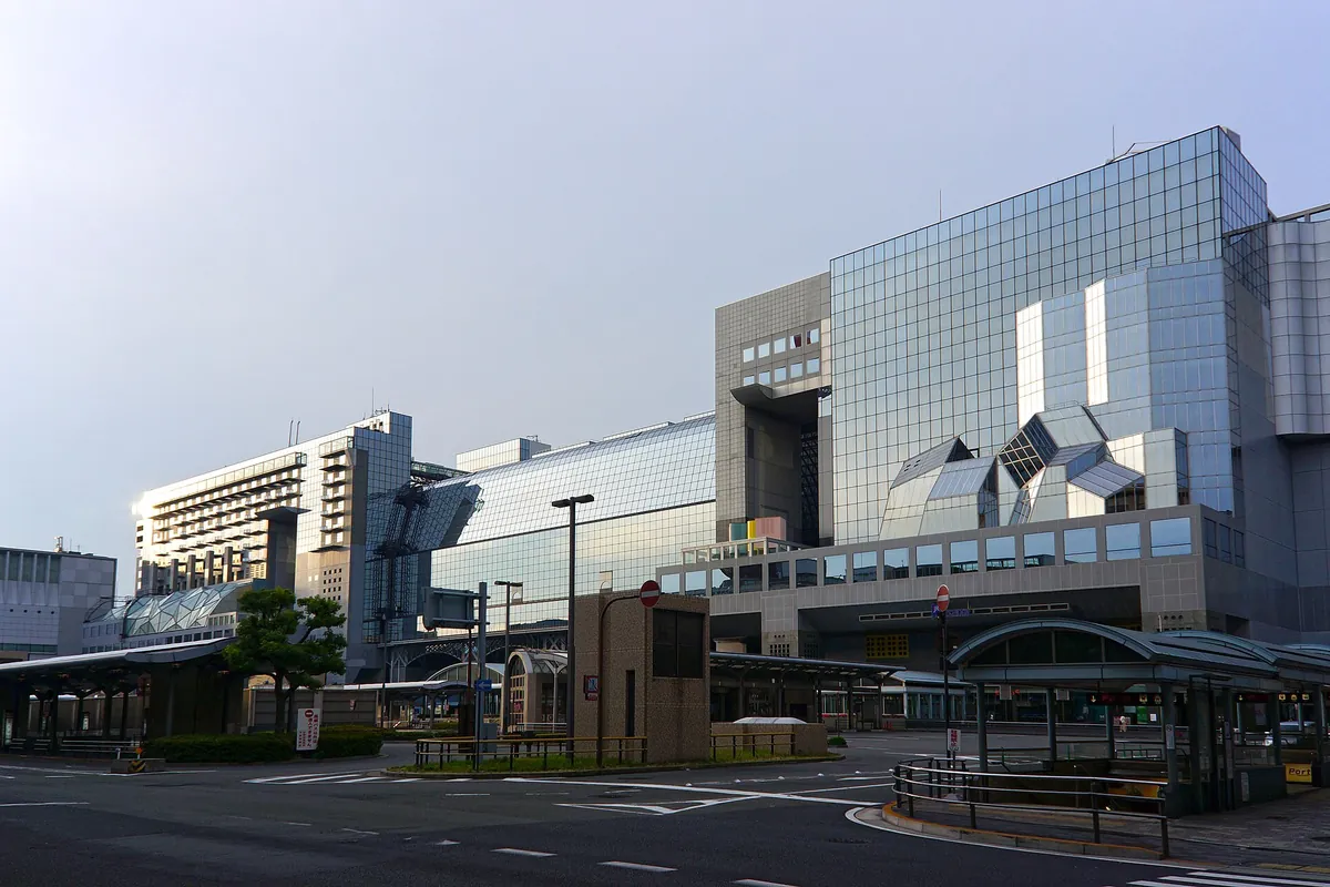 Exterior of the glass-and-steel Kyoto Station building with an empty street in front