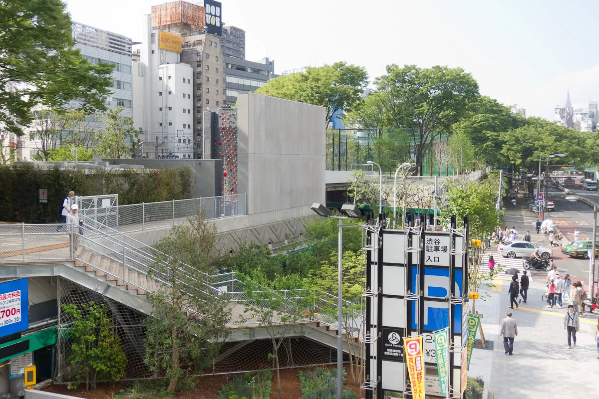 The Miyashita Park building in Shibuya, Tokyo, with a rooftop park, walkway, climbing wall, and a parking garage sign